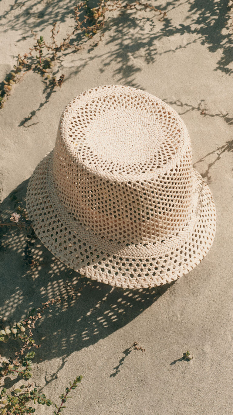 Bob beige pos&eacute; sur le sable avec lumi&egrave;re naturelle et ombres.