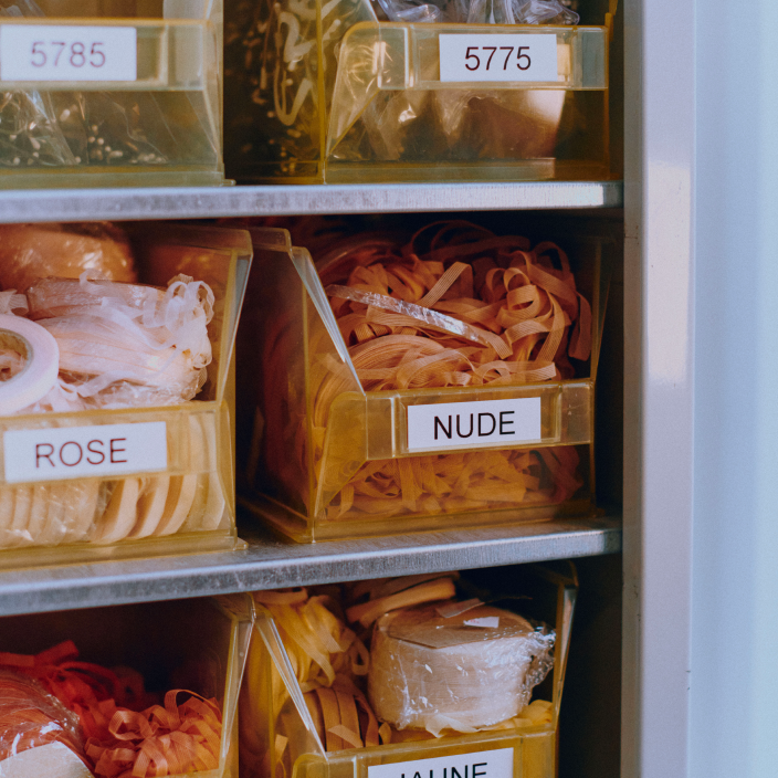 Archive boxes with colored thread samples labeled with reference numbers.